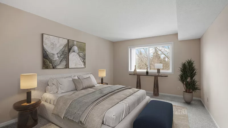 Bright, modern bedroom with a king bed, neutral bedding, bedside tables, wall art, and a window view of trees.